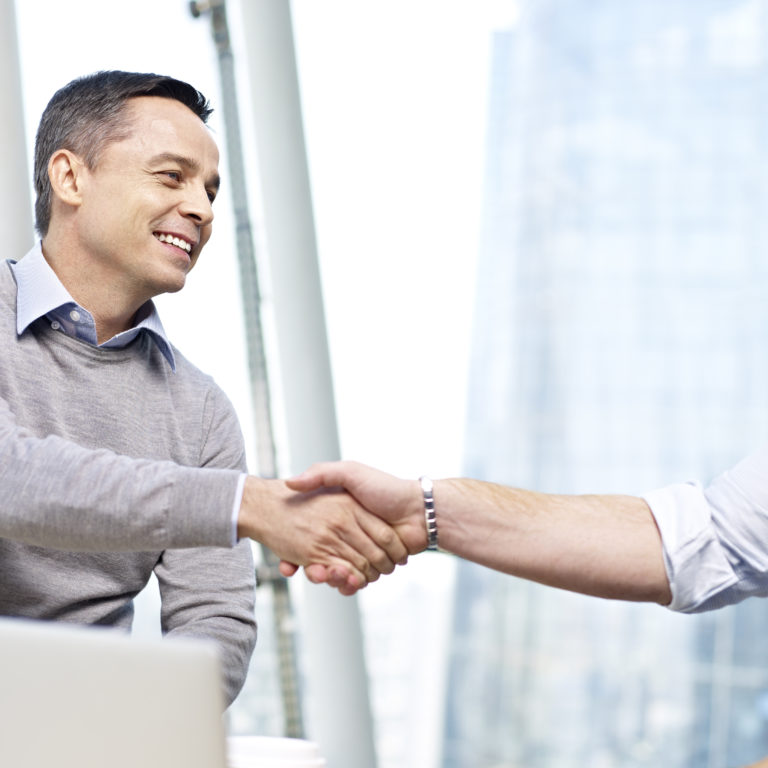 businesspeople shaking hands in office