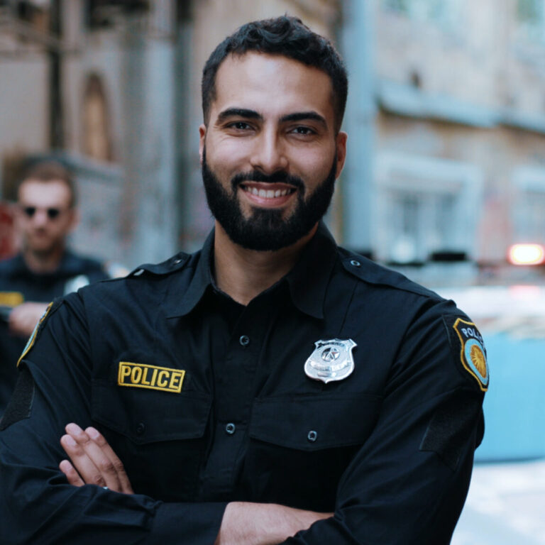 Smiling young man cops stand near patrol car look at camera enforcement happy officer police uniform auto safety security communication control policeman portrait close up slow motion police officer