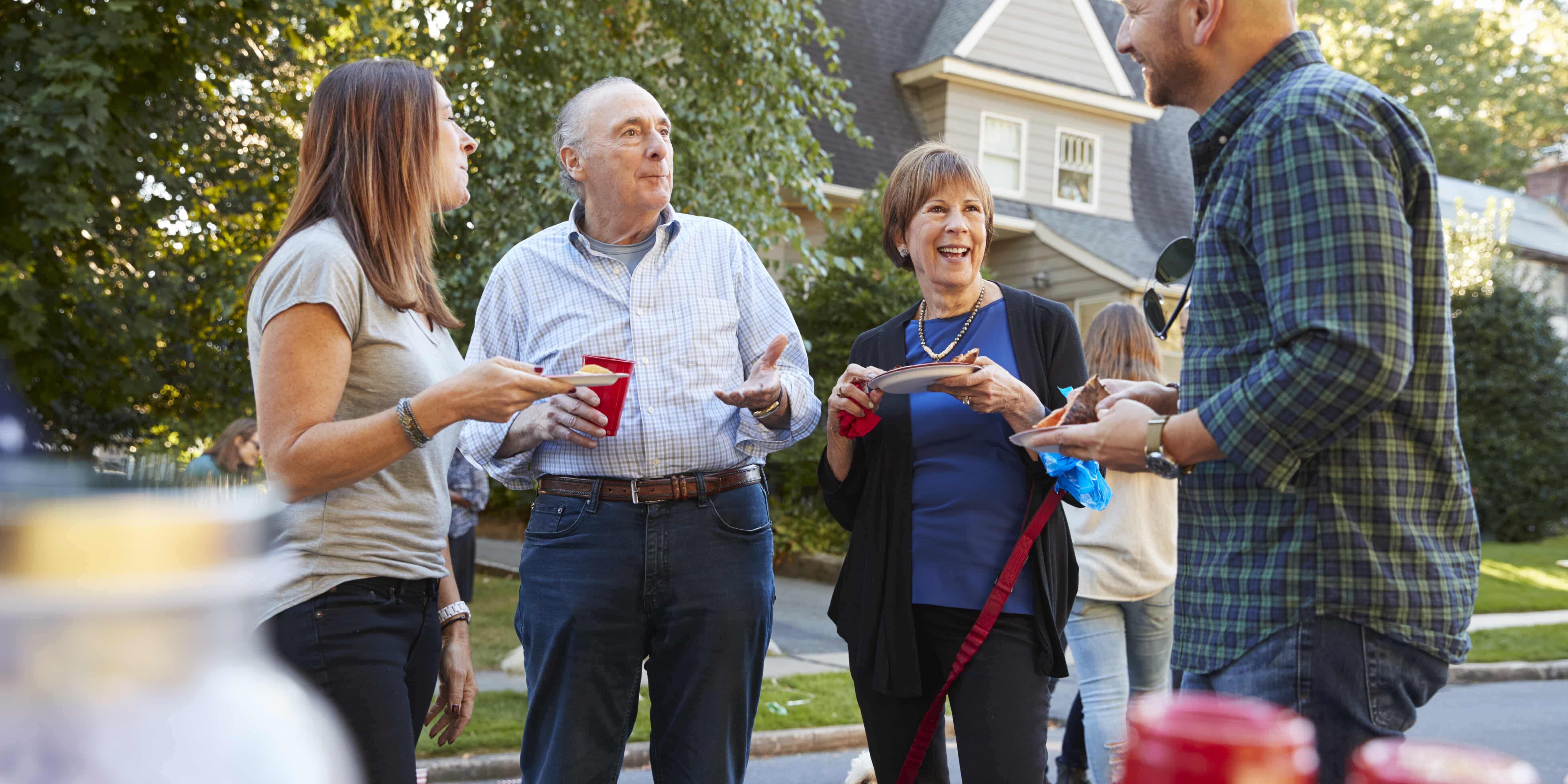 Middle aged and senior neighbours talking at a block party